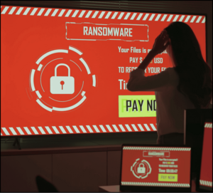 Ransomware warning on a monitor while an employee reacts.