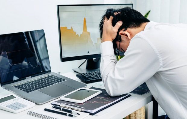 Business owner at a desk reviewing a sharp decline on a revenue chart.