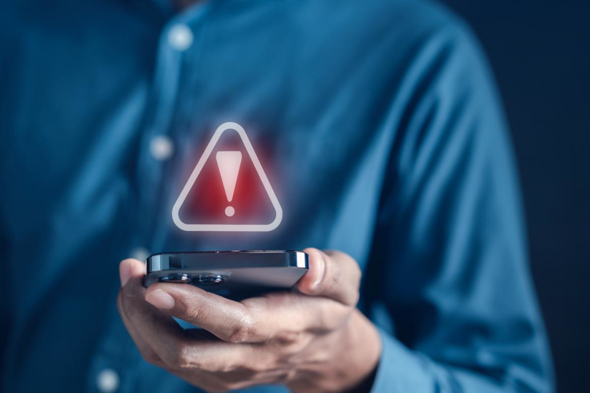 Man using phone with security icon floating above it