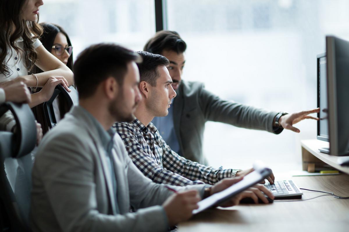Businesspeople in an office looking at a computer